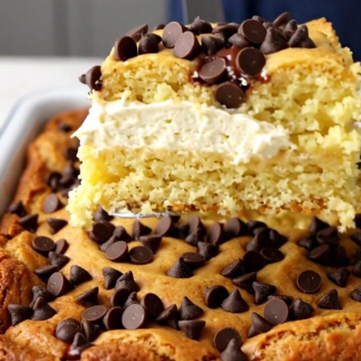 A top-down view of a golden-brown Chocolate Chip Gooey Butter Cake in a white rectangular baking dish.