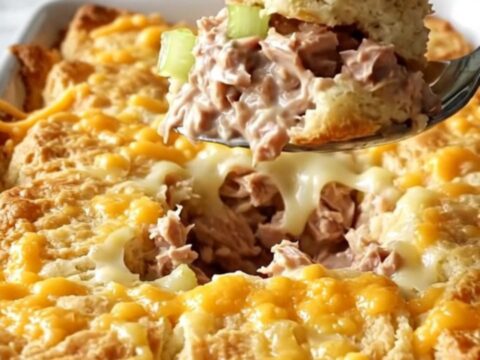 A golden, bubbling tuna melt biscuit bake in a white ceramic dish.