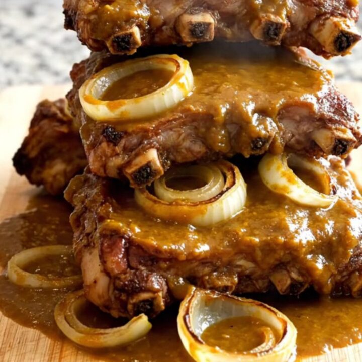 Close-up view of cooked pumpkin barbecue spareribs arranged on a wooden board with a glossy sauce.