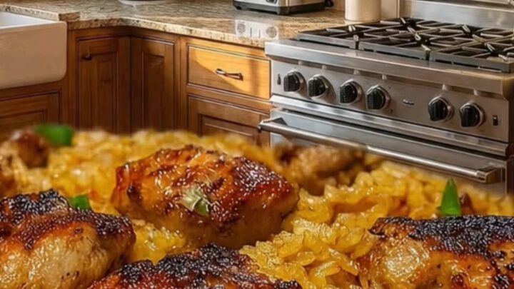A close-up shot of golden-brown crispy chicken thighs served over a bed of fluffy, herb-seasoned rice in a skillet.