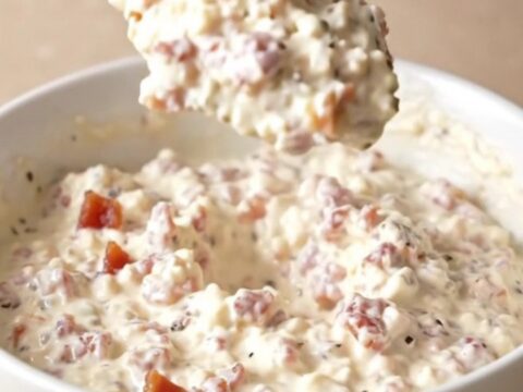 A creamy pepper jack dip in a slow cooker topped with crispy bacon pieces.