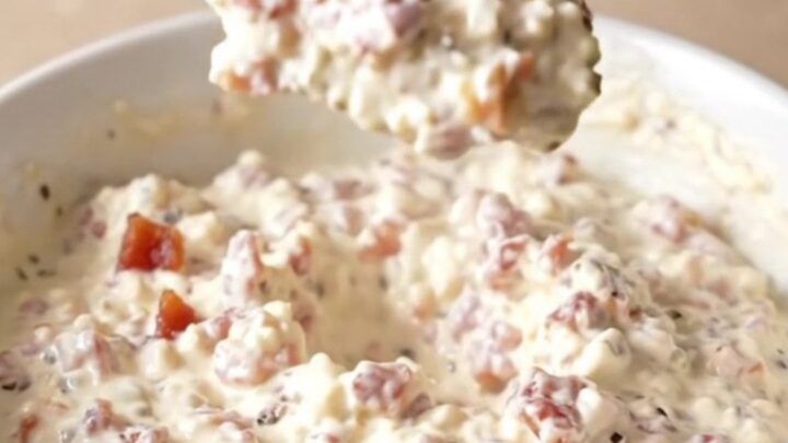 A creamy pepper jack dip in a slow cooker topped with crispy bacon pieces.
