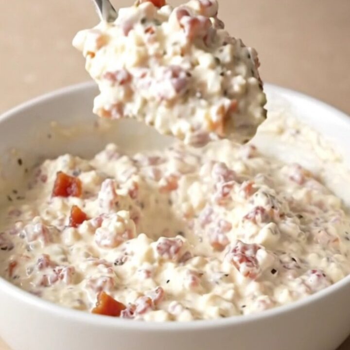 A creamy pepper jack dip in a slow cooker topped with crispy bacon pieces.