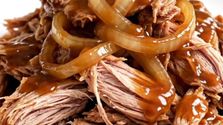 A close-up view of succulent Texas-style pulled pork served in a slow cooker.