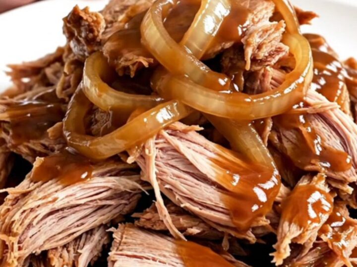 A close-up view of succulent Texas-style pulled pork served in a slow cooker.