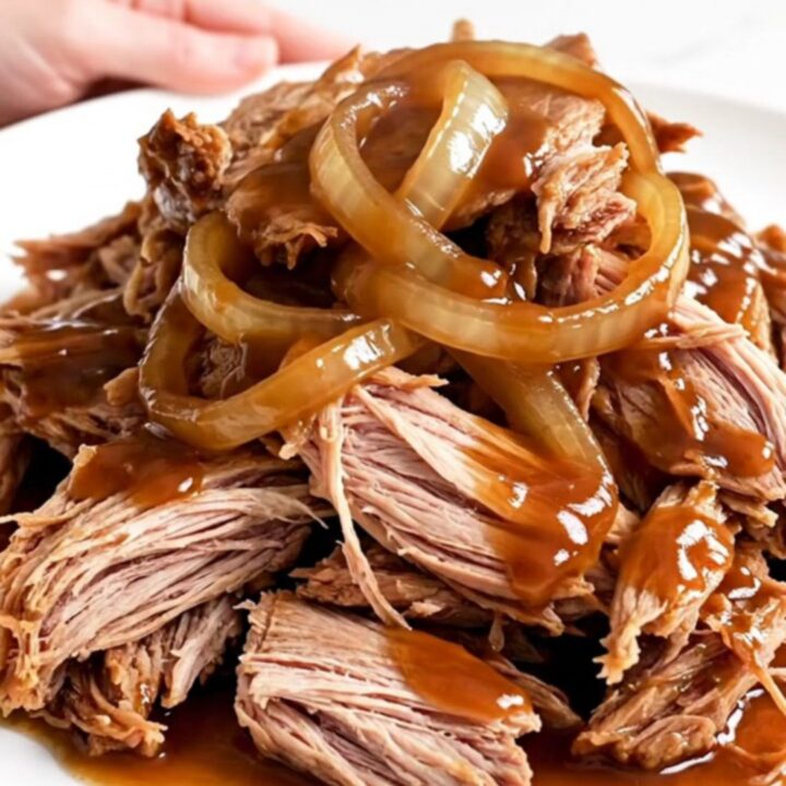 A close-up view of succulent Texas-style pulled pork served in a slow cooker.