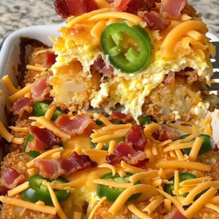 A golden brown potato tot and jalapeno breakfast casserole in a white rectangular baking dish.