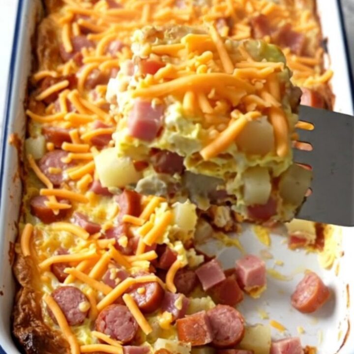 A golden-brown breakfast casserole in a white baking dish on a quartz countertop.