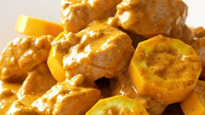 A warm, creamy chicken and yellow squash casserole served in a white bowl