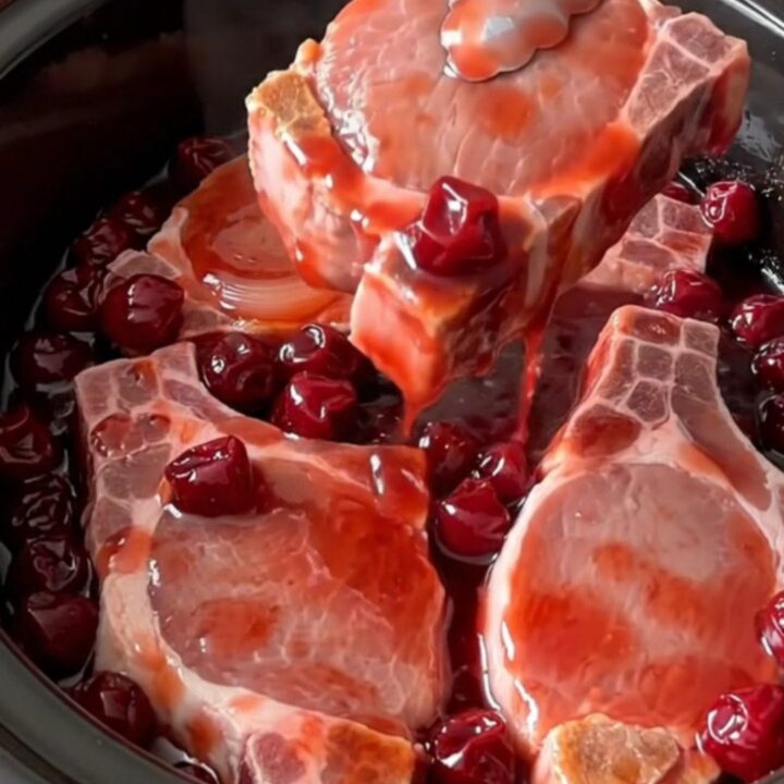 Six boneless pork chops fanned in a slow cooker, topped with sweet onion rings and cherry pie filling.