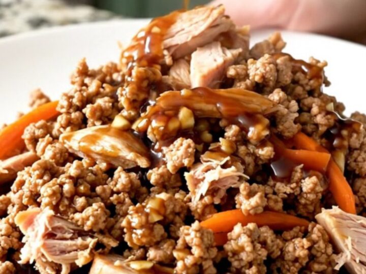 A close-up of tender Mongolian ground turkey with shredded carrots in a slow cooker, showing a rich, dark, and glossy sauce.