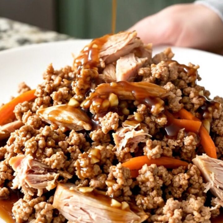 A close-up of tender Mongolian ground turkey with shredded carrots in a slow cooker, showing a rich, dark, and glossy sauce.