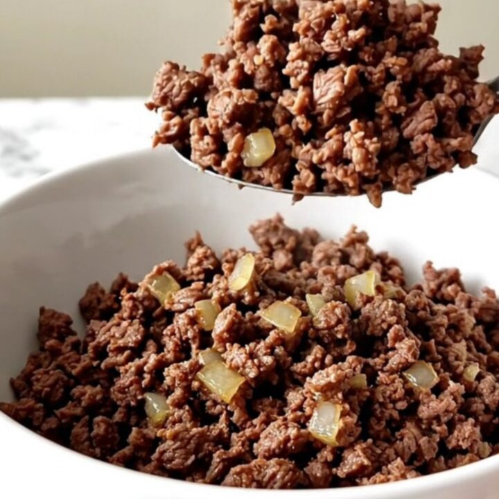 A close-up of a slow cooker filled with savory, cooked ground beef and onion mixture.