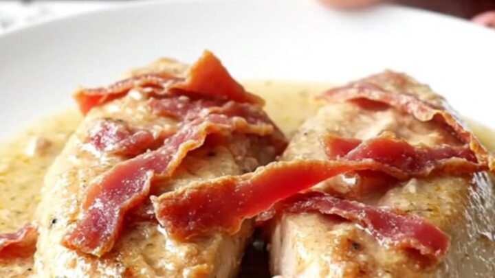 A close-up of tender chicken breasts covered in a creamy, savory sauce with thin slices of dried beef
