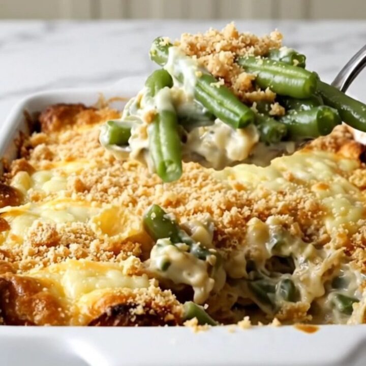 A vintage-style Swiss green bean casserole in a ceramic dish, topped with golden cornflakes and melted Swiss cheese.