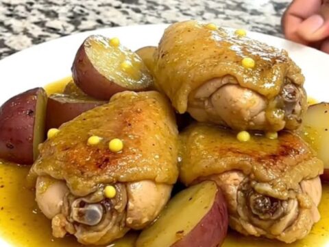 Slow cooker garlic Dijon chicken and red potatoes served in a shallow bowl with sauce.