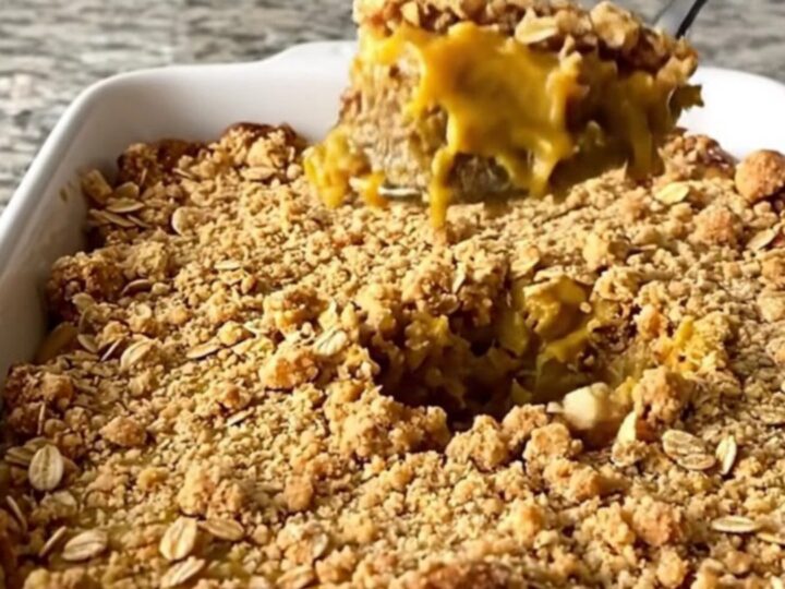 A large rectangular ceramic dish filled with golden-brown pumpkin pie crisp on a speckled granite countertop.