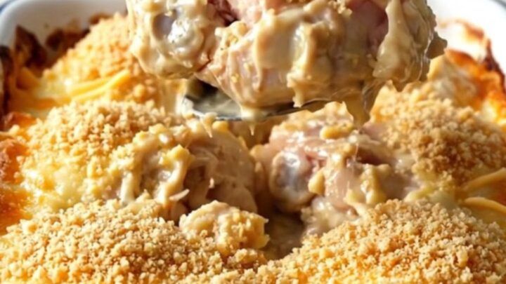 A golden, bubbling cheesy garlic bread chicken bake in a rectangular white enameled dish.