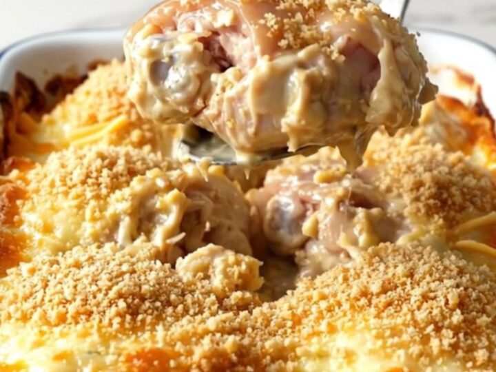 A golden, bubbling cheesy garlic bread chicken bake in a rectangular white enameled dish.