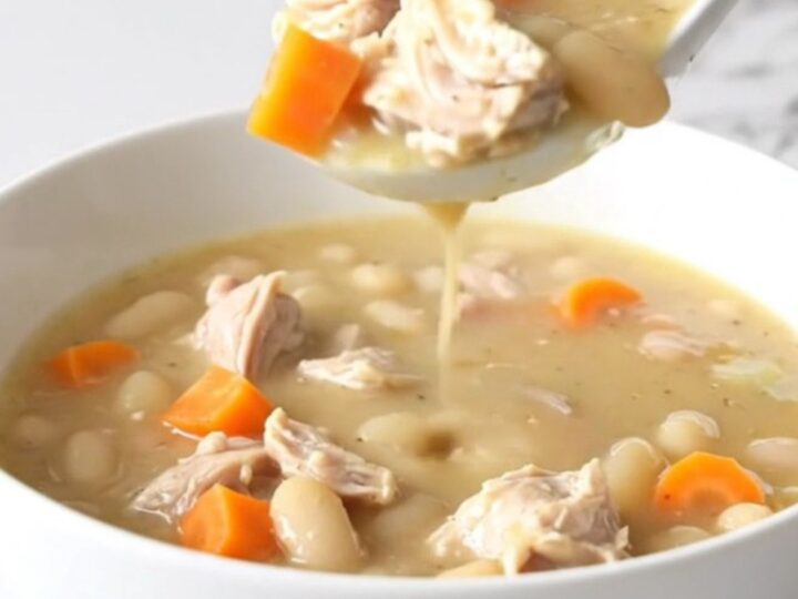 A bowl of creamy lemon pepper chicken and white bean soup with visible carrots.