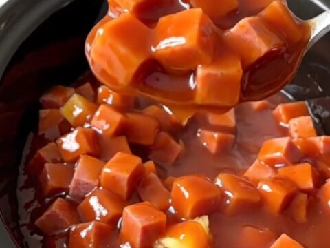 A close-up of slow cooker sweet and sour ham with vibrant pineapple chunks and green peppers in a glossy sauce.