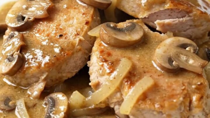 A close-up of creamy slow cooker turkey stroganoff with mushrooms and onions served on a white plate.