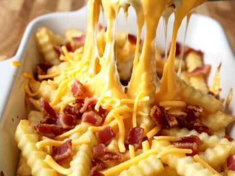 A top-down view of a rectangular baking dish filled with golden baked fries