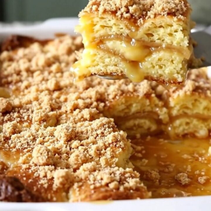 A top-down view of a golden brown breakfast casserole in a white dish, topped with cinnamon streusel.