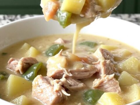 A steaming bowl of creamy turkey poblano potato chowder with visible chunks of turkey and diced vegetables.