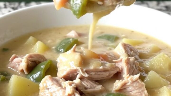 A steaming bowl of creamy turkey poblano potato chowder with visible chunks of turkey and diced vegetables.