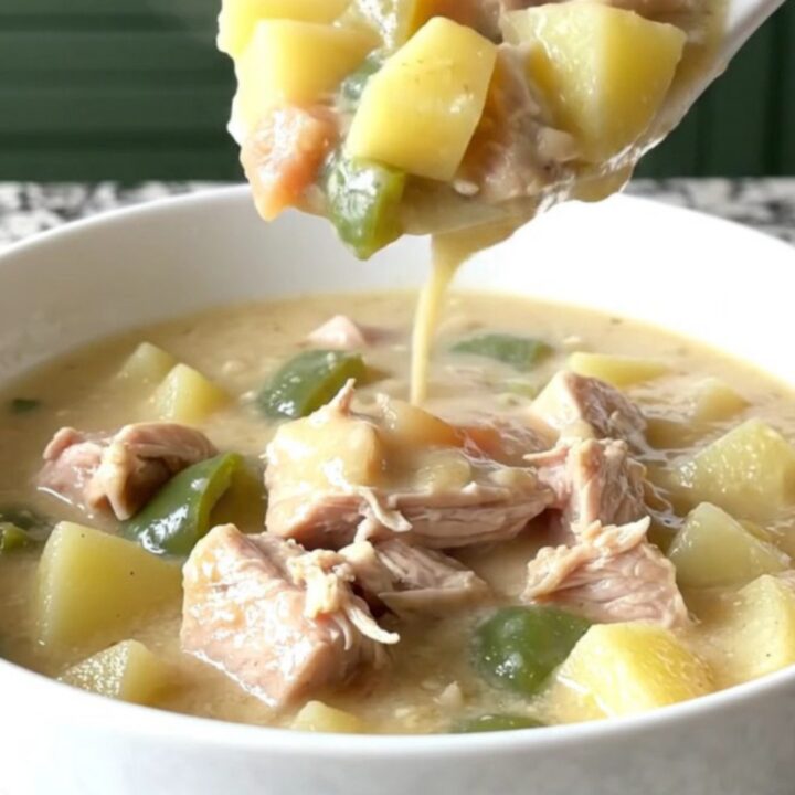 A steaming bowl of creamy turkey poblano potato chowder with visible chunks of turkey and diced vegetables.