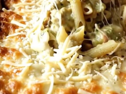 A bubbly, golden brown creamy salsa verde turkey penne bake in a white ceramic dish on a beige counter.