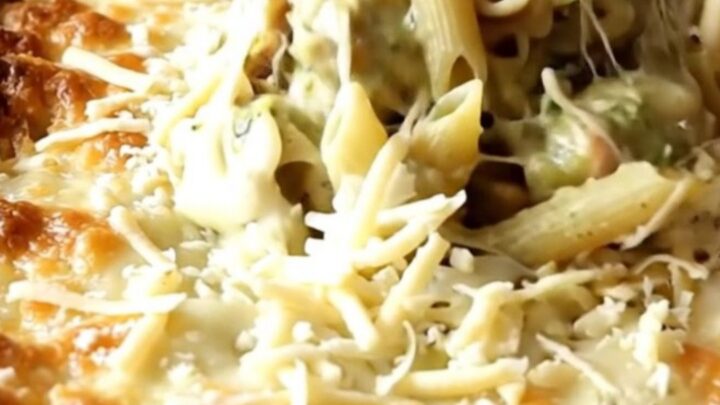 A bubbly, golden brown creamy salsa verde turkey penne bake in a white ceramic dish on a beige counter.