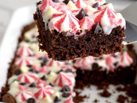 A top-down view of Peppermint Bark Magic Bars in a white ceramic baking dish on a speckled quartz counter.