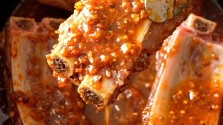 A close-up of tender, slow-cooked pork spareribs coated in a glistening, sticky chili lime glaze.