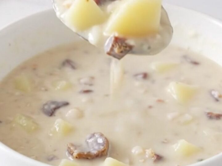A top-down view of the creamy potato and chipped beef soup served in a white bowl on a quartz countertop.