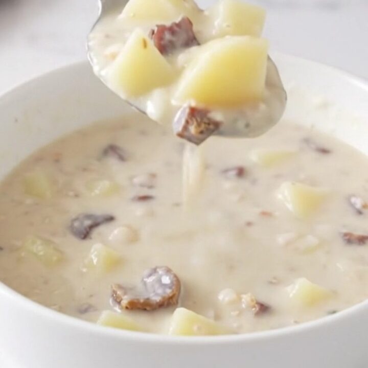 A top-down view of the creamy potato and chipped beef soup served in a white bowl on a quartz countertop.