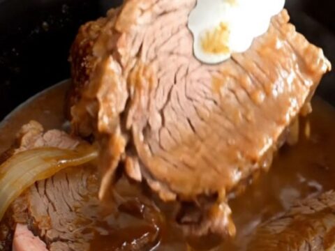 A close-up of tender, slow-cooked rump roast slices covered in a rich
