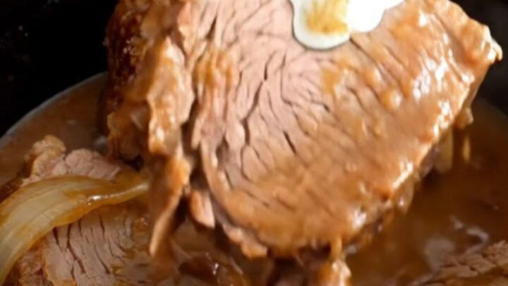 A close-up of tender, slow-cooked rump roast slices covered in a rich