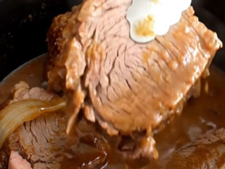 A close-up of tender, slow-cooked rump roast slices covered in a rich