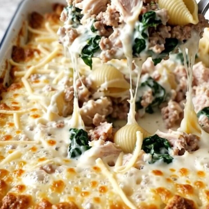 A top-down view of a rectangular white baking dish filled with pasta shells, ground turkey, and spinach in a creamy sauce.