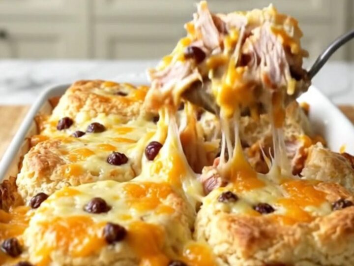 A golden, bubbling pimento cheese turkey burger biscuit bake in a rectangular white ceramic dish.