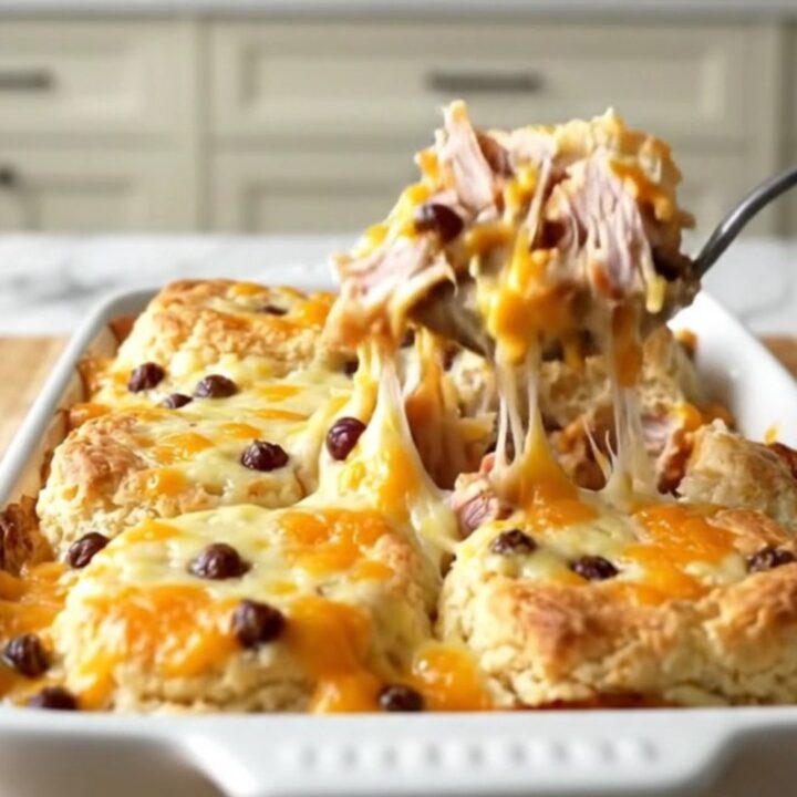 A golden, bubbling pimento cheese turkey burger biscuit bake in a rectangular white ceramic dish.