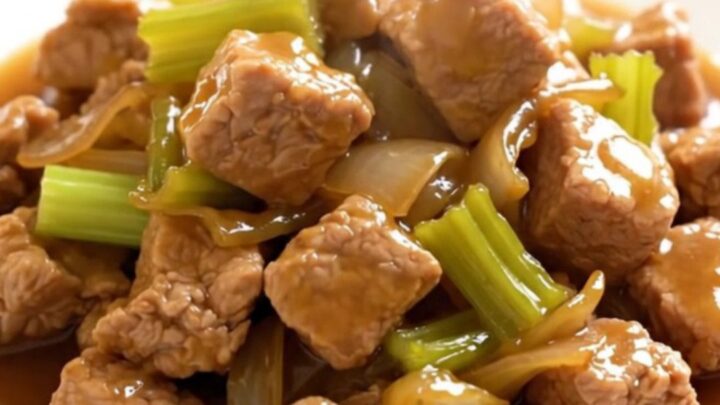 A close-up of a bowl filled with slow-cooked pork chop suey featuring tender pork, sliced celery