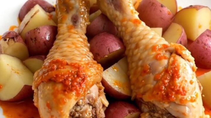 A close-up of tender, skinless chicken drumsticks and quartered red potatoes in a dark slow cooker