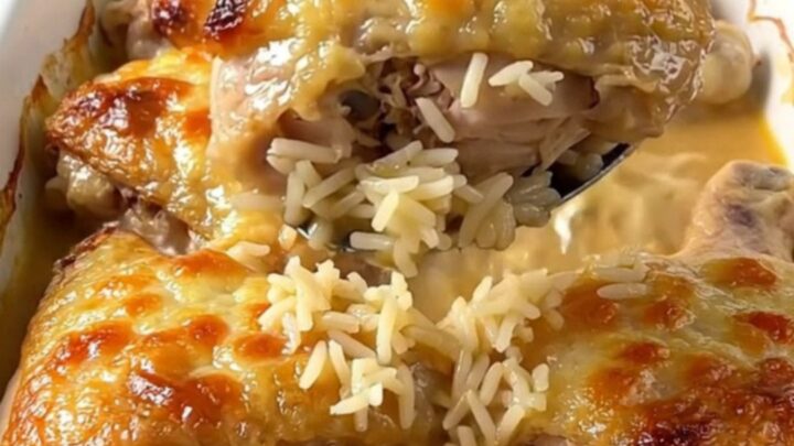A top-down view of a rectangular baking dish filled with golden baked chicken thighs and savory rice.