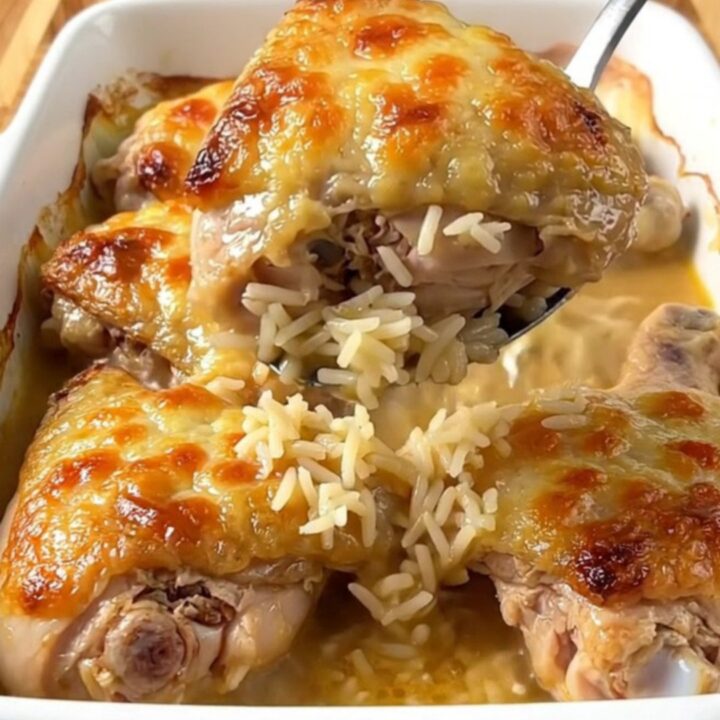 A top-down view of a rectangular baking dish filled with golden baked chicken thighs and savory rice.