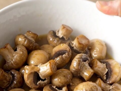 A close-up of tender, whole white button mushrooms glistening in a light garlic butter ranch sauce.