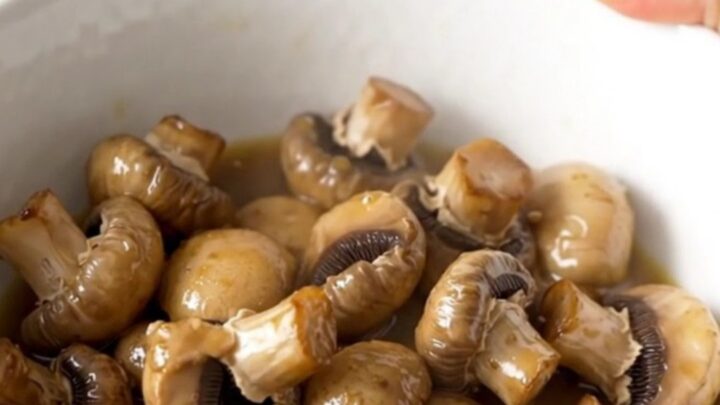 A close-up of tender, whole white button mushrooms glistening in a light garlic butter ranch sauce.
