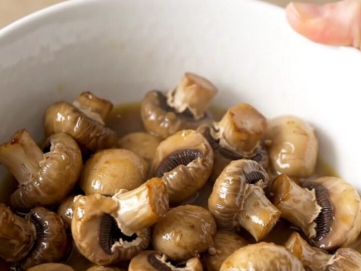 A close-up of tender, whole white button mushrooms glistening in a light garlic butter ranch sauce.